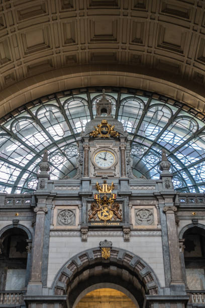 close-up do relógio e o brasão de armas na estação central de antuérpia, bélgica. - antwerp station center glass - fotografias e filmes do acervo