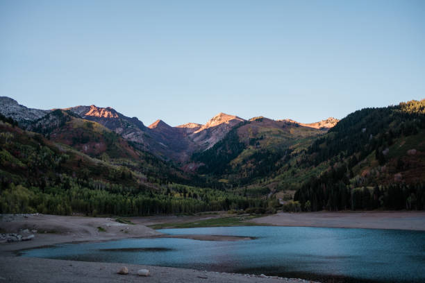 istock Mountain Peaks Lit by a Sunset about a Alpine Lake in Utah 1050817894