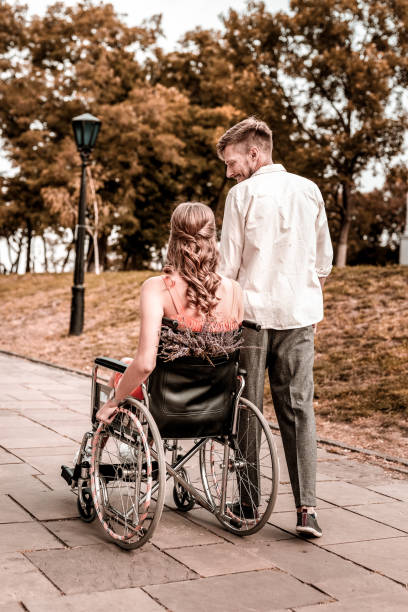 istock Happy man looking at his disabled girlfriend while walking with her 1050820850