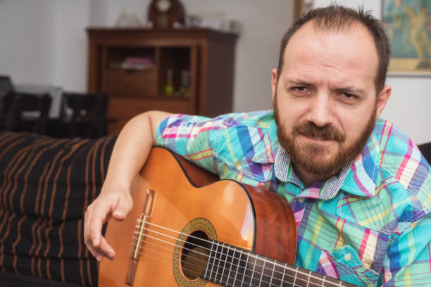 istock Young man musician playing acoustic guitar 1050821424