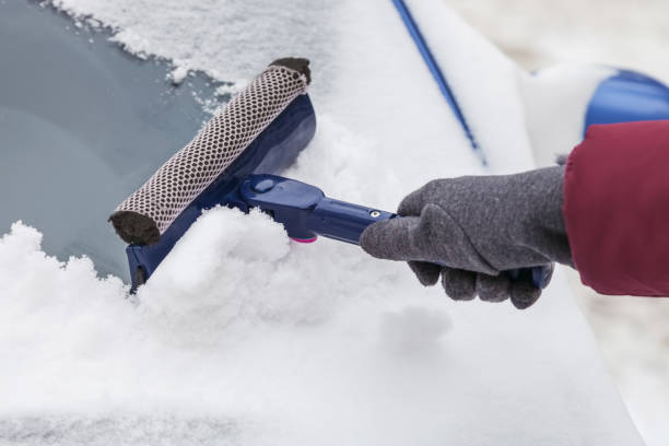 reinigung der windschutzscheibe von schnee mit schaber - blizzard ice damaged snow stock-fotos und bilder