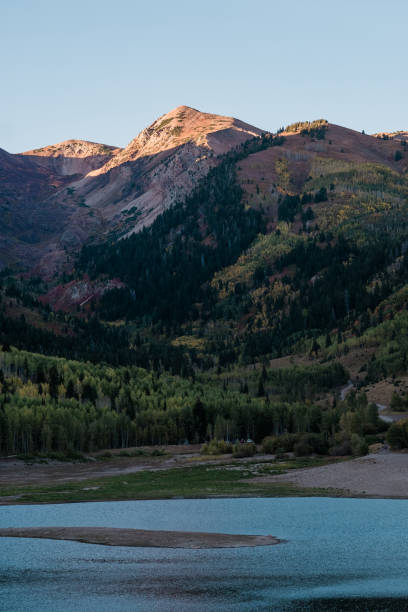 istock Mountain Peaks Lit by a Sunset about a Alpine Lake in Utah 1050827104