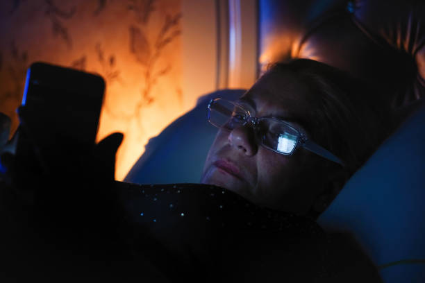 istock Senior woman using mobile phone in bed before falling sleep 1050828106