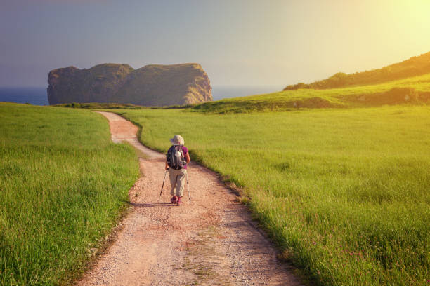 peregrinos caminando hacia la iglesia de san martín en la costa de llanes a la playa de las camaras, asturias, españa - asturiana fotografías e imágenes de stock