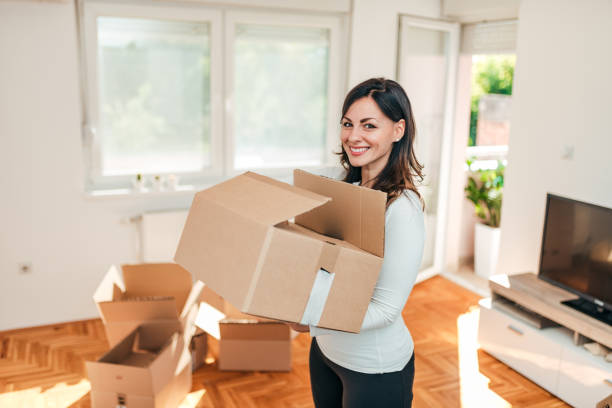 istock Cheerful young woman holding box. Moving day. 1050832230