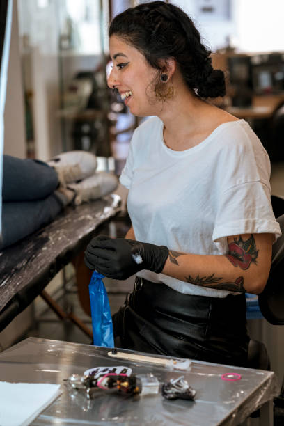 istock Young woman preparing the tattoo machine and inks. 1050834994