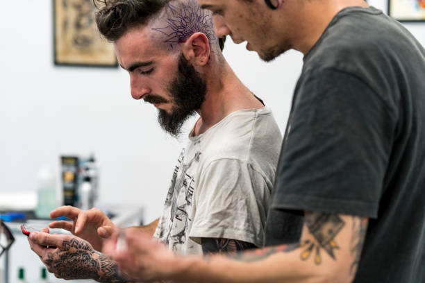 istock Tattooist placing the drawing on the head. 1050835500