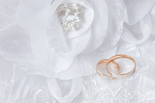 istock Wedding rings on wedding card, on a white wedding dress 1050835946