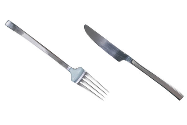 Isolated Crossed Knife and Fork Utensils in Dark Grey Metal