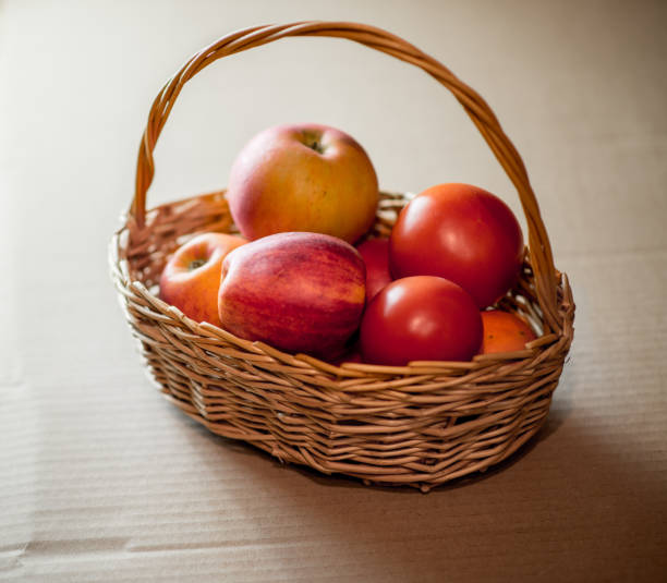 リンゴとトマトは、籐のバスケット - plum fruit basket wicker ストックフォトと画像