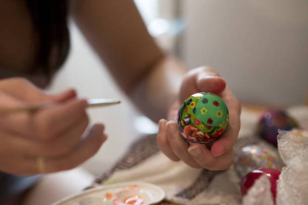 istock a person draws a brush on an Easter egg with different colors 1050839650