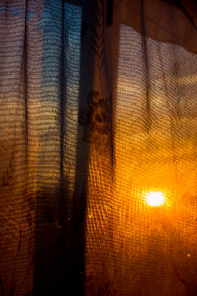 istock Through the curtain shines the setting sun 1050839818