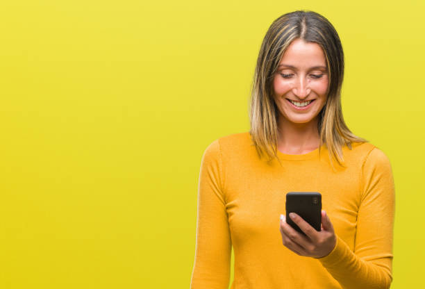 istock Young beautiful woman sending message using smartphone over isolated background with a happy face standing and smiling with a confident smile showing teeth 1050843290
