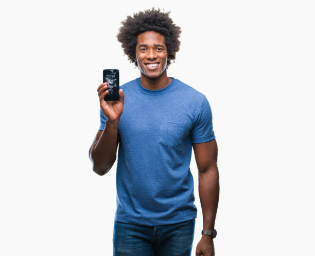 istock Afro american man holding broken smartphone over isolated background with a happy face standing and smiling with a confident smile showing teeth 1050846828