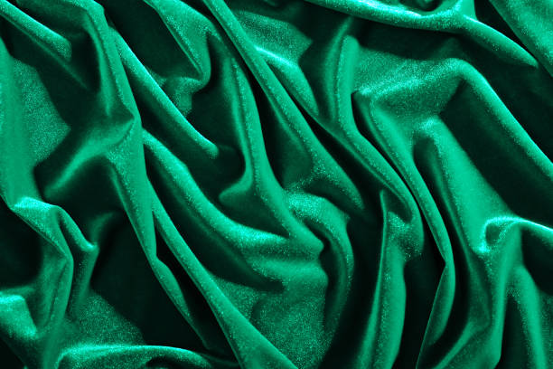 istock Emerald color velvet textiles for background or texture, wrinkled and shadows 1050847438