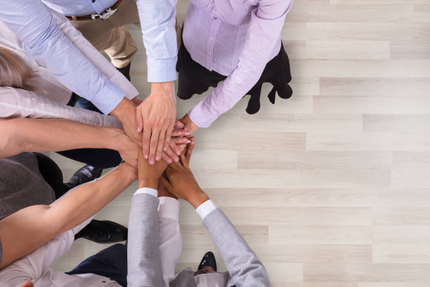 istock Group Of Businesspeople Stacking Their Hands 1050851188