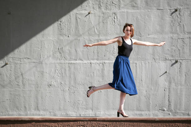 istock young girl posing against a concrete wall, dressed in black, hard light and shadows 1050851518