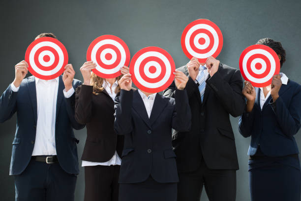 istock Group Of Businesspeople Hiding Their Faces Behind Dartboard 1050851996