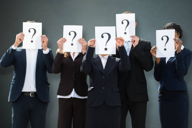 istock Businesspeople Hiding Their Faces Behind Question Mark Sign 1050851998