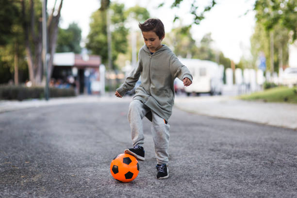 istock Boy play with football ball 1050854890