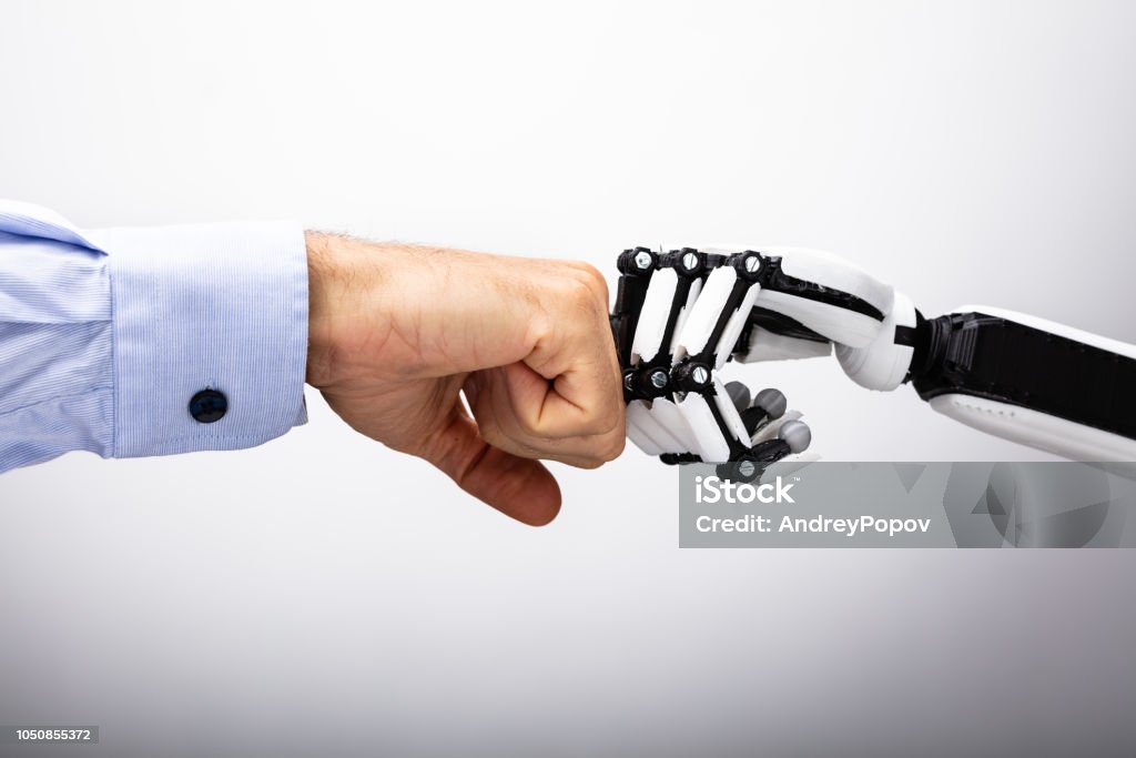 Human Hand And Robot Making Fist Bump Human Hand And Robot Making Fist Bump On Gray Background Robot Stock Photo