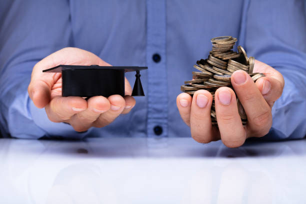 istock Person Holding Graduation Hat And Coins 1050855494