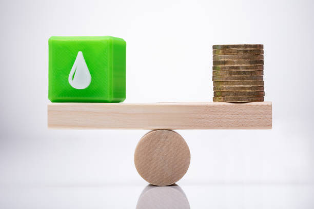istock Cubic Block With Waterdrop Icon And Coins Balancing On Seesaw 1050855542