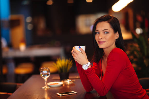 Beautiful young woman drinking coffee in a cafe