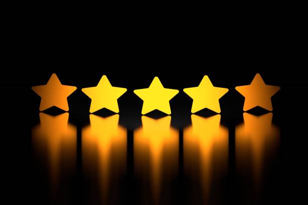 istock Five golden stars over shiny reflective surface on black background 1050865422