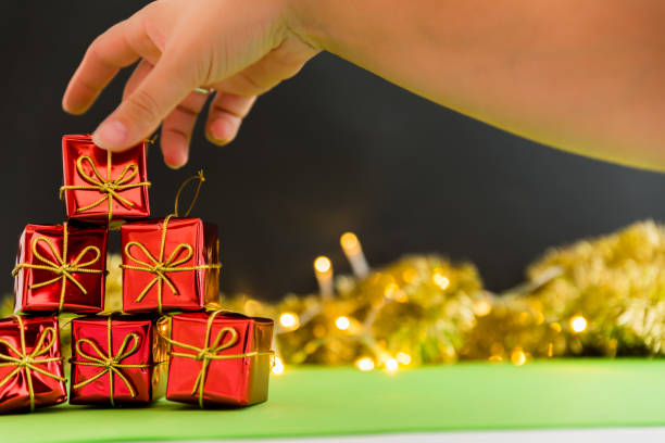 istock woman's hand putting gift on christmas background 1050869682