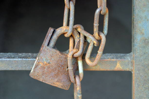istock The old lock on the gate in yard-well on rusty chain. 1050870304