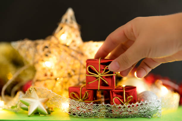 istock woman's hand placing a gift on christmas background 1050871090