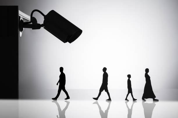 Silhouette Of CCTV Camera Over People Walking On Reflective Background