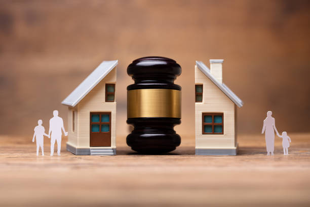 istock Gavel Between Split Family Figures And House Model 1050881886