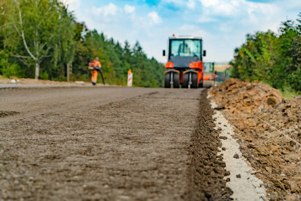 istock vibrating roller machines are compacting asphalt on the road. 1050888034