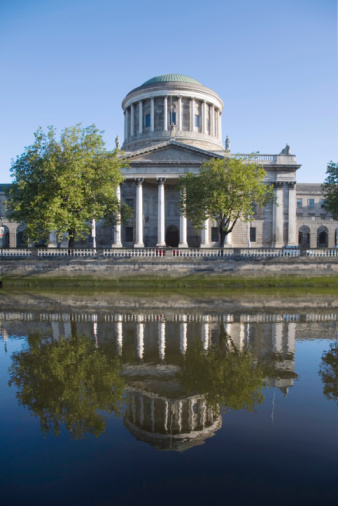 The Four Courts building reflected in the River Liffey, Dublin. This central landmark is over 200 years old and is the Republic of Irelands main courts building.
