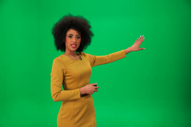 Weather forecaster on green background Young weather woman in front of a green background with small remote in her other hand. chroma key photos stock pictures, royalty-free photos & images