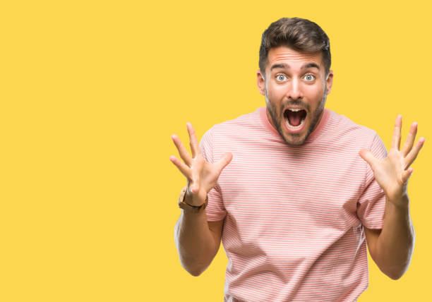 istock Young handsome man over isolated background celebrating crazy and amazed for success with arms raised and open eyes screaming excited. Winner concept 1050892450