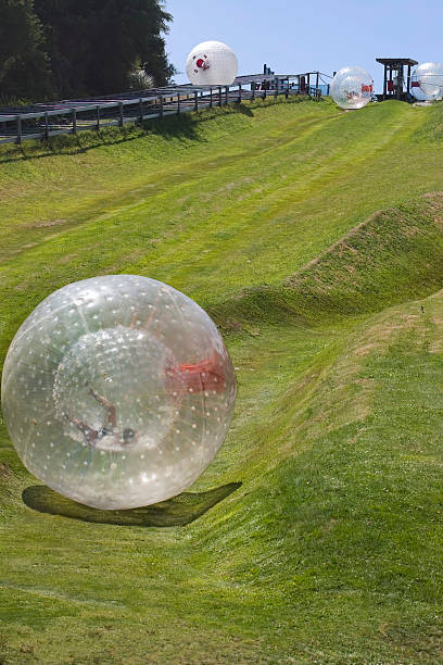 Zorbing down a hill Rolling down a hill in a Zorb ball zorb ball stock pictures, royalty-free photos & images