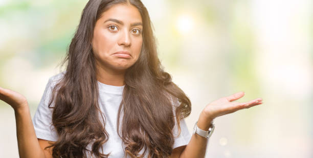 istock Young beautiful arab woman over isolated background clueless and confused expression with arms and hands raised. Doubt concept. 1050898896