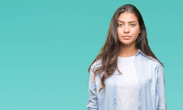 istock Young beautiful arab woman over isolated background with serious expression on face. Simple and natural looking at the camera. 1050899074