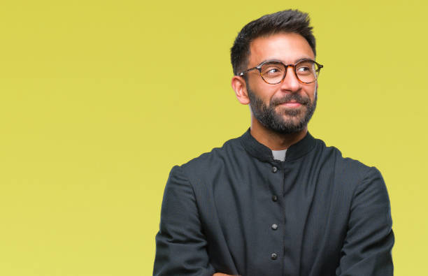 adult hispanic catholic priest man over isolated background smiling looking side and staring away thinking. - mannered imagens e fotografias de stock