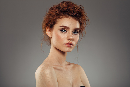 Red haired woman with shiny and curly hairstyle