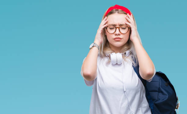 istock Young blonde student woman wearing glasses and backpack over isolated background suffering from headache desperate and stressed because pain and migraine. Hands on head. 1050905988