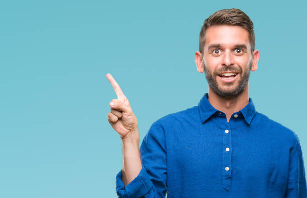 istock Young handsome man over isolated background with a big smile on face, pointing with hand and finger to the side looking at the camera. 1050906810
