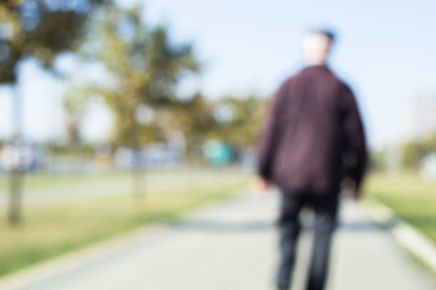 Defocused grandparent walk on the sidewalk. Blurry focus scene