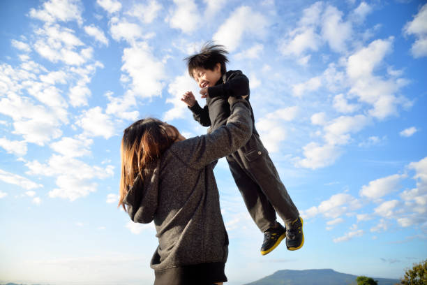 istock Young mother throws up her son in the sky 1050912128