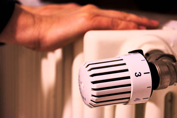 istock warm the cold hands on the radiator 1050912628