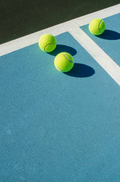 tre palline da tennis sul campo da tennis blu - tennis court tennis ball ball foto e immagini stock