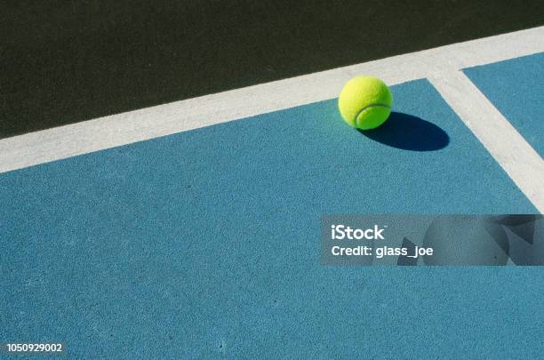 Tennis Ball Rests On Blue Tennis Court Stock Photo - Download Image Now - Tennis, Sports Court, Blue